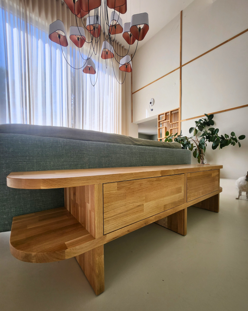 Banquette basse en chêne massif sur mesure placée derrière un canapé